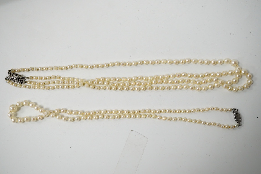 A double strand graduated culture pearl necklace, with marcasite set sterling clasp, 46cm and one other single strand cultured pearl necklace. Condition - fair